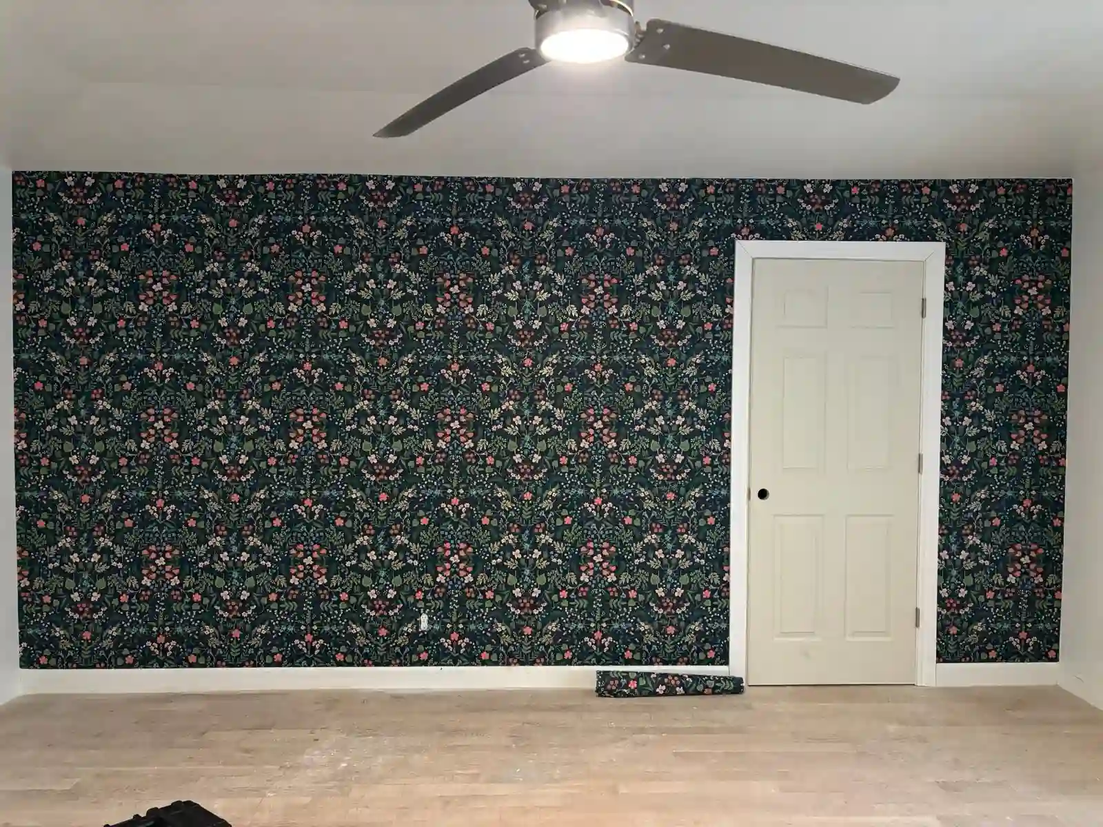 Wallpaper installer carefully applying wallpaper to a wall